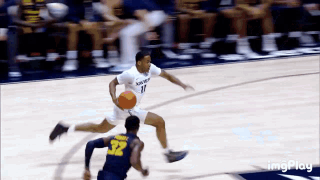 a basketball player with the number 32 on his back is dribbling the ball