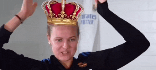 a woman is wearing a crown on her head and making a funny face .