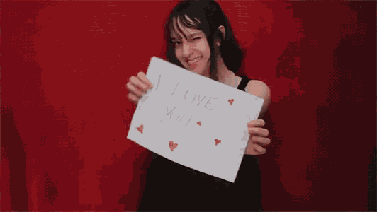 a young girl is holding a sign that says i love you