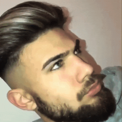 a man with a beard and gray hair looks down