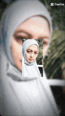 a woman in a white hijab is displayed on a screen that says cap cut