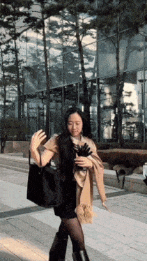 a woman wearing a scarf and gloves is walking down a sidewalk