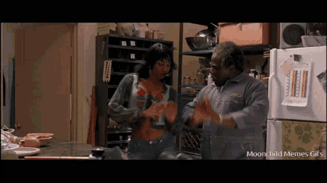 a man and a woman are dancing in a kitchen with the words moonchild memes gifs on the bottom