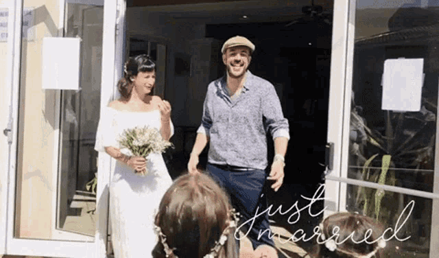 a bride and groom are just married in front of a glass door .
