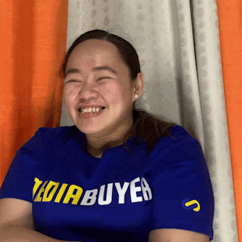 a woman wearing a blue shirt with the word buyer on the front