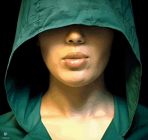a woman wearing a green jacket with a hood and the word valdez on the bottom right