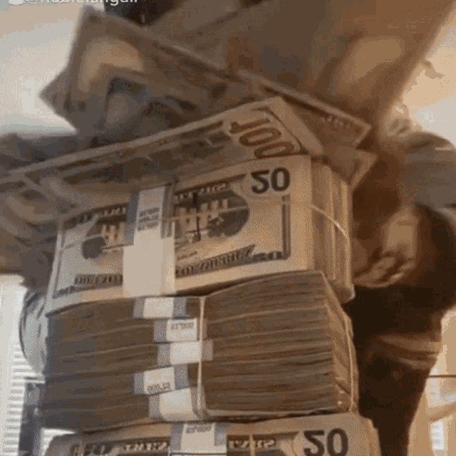 a stack of 50 dollar bills stacked on top of 100 dollar bills