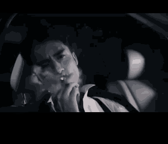 a man is smoking a cigarette in a car