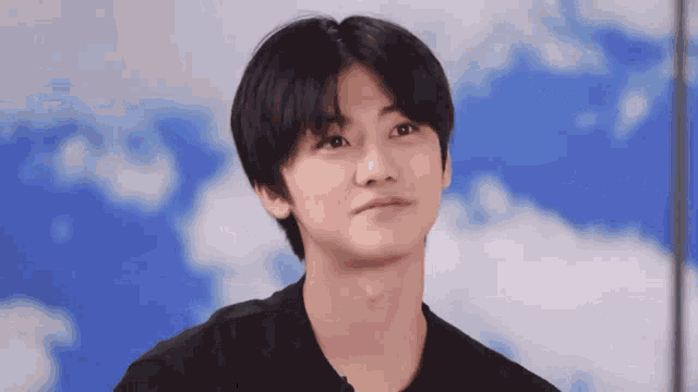 a young man in a black shirt is making a funny face .