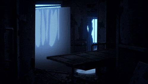 a dark room with a light shining through a doorway