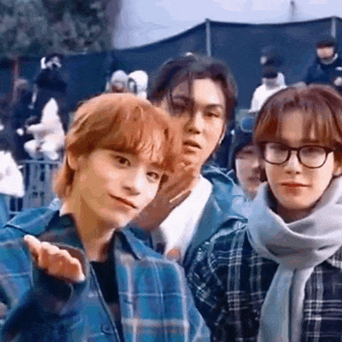 a group of young men are standing next to each other and making funny faces .
