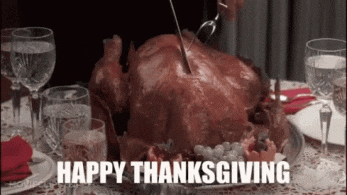 a person is cutting a turkey on a table with the words `` happy thanksgiving '' written on it .