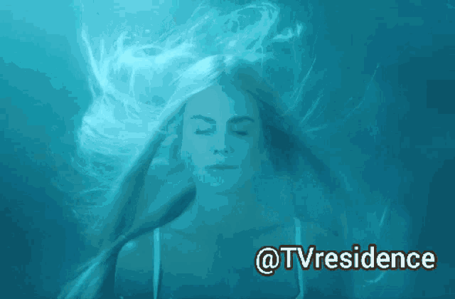 a woman with her eyes closed is floating in the water with @tvresidence written below her
