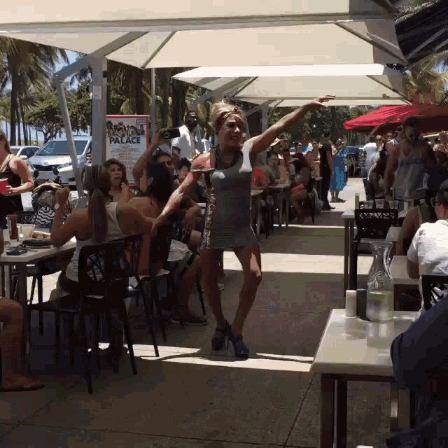 a woman in a dress is dancing in front of a sign that says palace