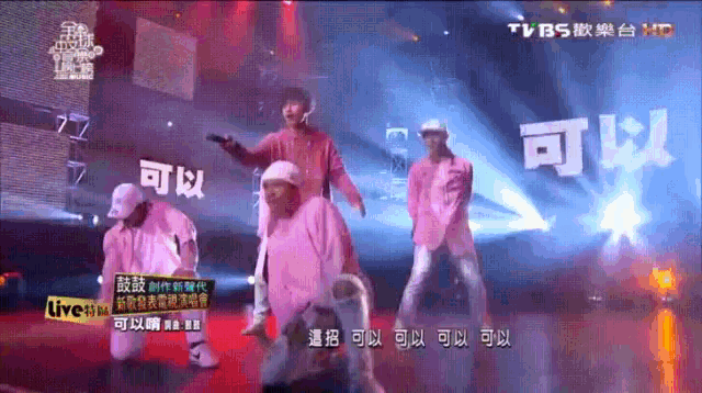 a group of people dancing on a stage with chinese writing on the bottom