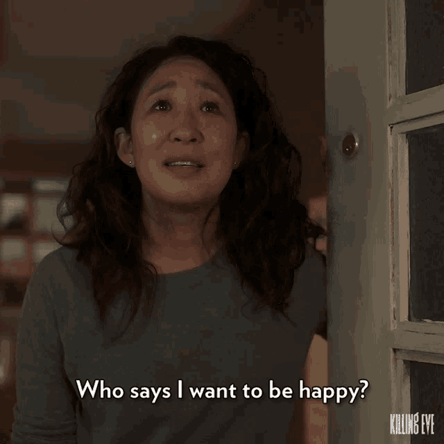 a woman says who says i want to be happy in front of a killing eve door