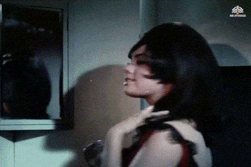 a woman looks at her reflection in a mirror with a watermark that says mr. studios