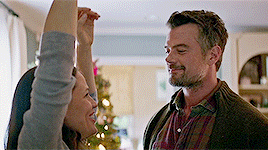 a man and a woman are standing next to each other in a living room .