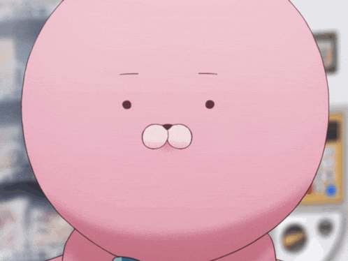 a pink stuffed animal with a bunny face is being held by a person