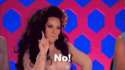 a woman with long hair and a flower in her hair is making a no sign .