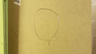 a person 's hand is visible through a hole in a wall