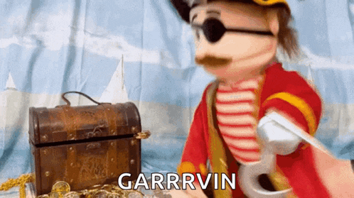 a puppet dressed as a pirate is holding a sword in front of a treasure chest with the word garrivin above it