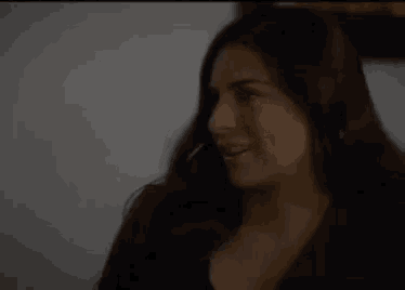 a close up of a woman with long hair smiling .