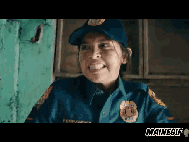 a woman in a police uniform is making a funny face while wearing a hat .