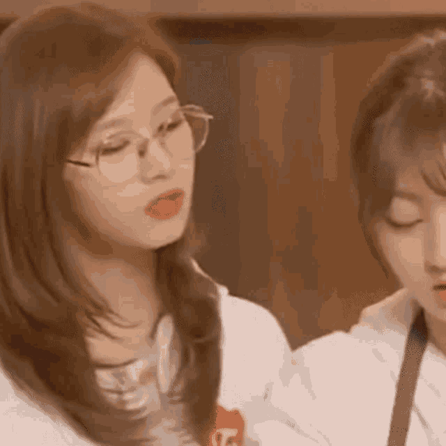 a close up of two women wearing glasses and a white shirt