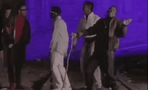 a group of men are standing next to each other in front of a purple background .