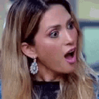 a woman with a surprised look on her face is wearing earrings .