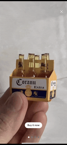 a person is holding a six pack of corona beer