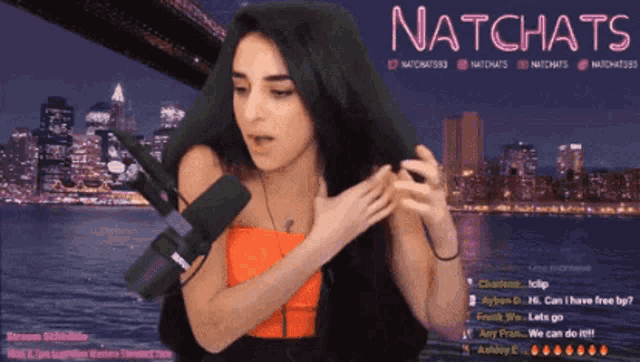 a woman stands in front of a microphone on a screen that says ' natchats ' in pink