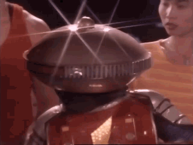 a man in a red tank top is standing next to a robot that says ' nintendo ' on it 's head