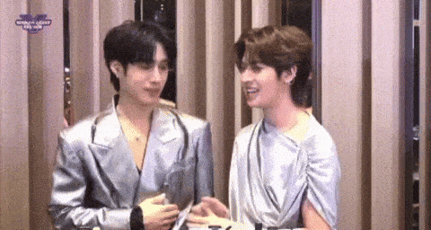 a couple of men are standing next to each other and talking .