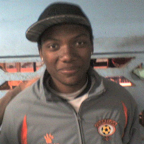 a man wearing a hat and a jacket with a soccer ball and the word united on it