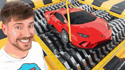 a man is smiling in front of a machine that is shredding a red sports car