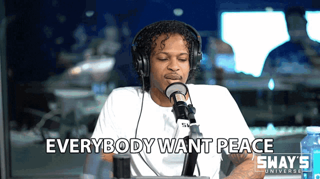 a man wearing headphones is talking into a microphone with the words " everybody want peace " written below him