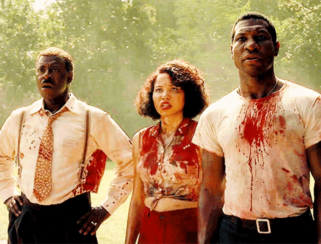 a man and a woman are standing next to each other with their shirts covered in blood