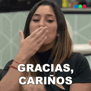 a woman covering her mouth with her hand and the words gracias cariños written above her