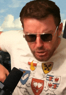 a man wearing sunglasses and a t-shirt with shields on it