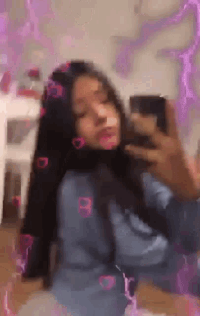 a girl is taking a selfie with a cell phone .