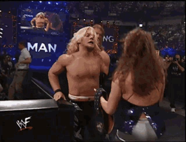 a group of wrestlers are standing in front of a sign that says ' wwe '