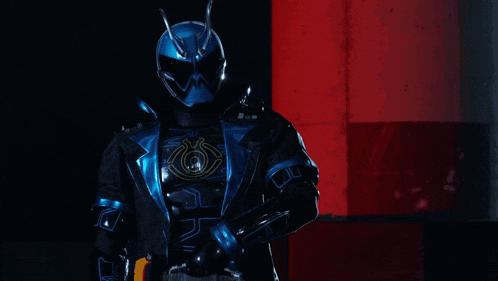 a person in a blue glowing costume is walking in a dark room