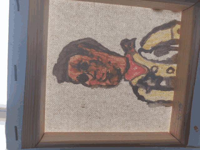 a canvas with a drawing of a man 's face on it and a wooden frame