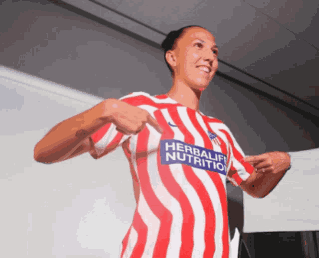 a woman wearing a red and white striped shirt that says herbalife nutrition on it