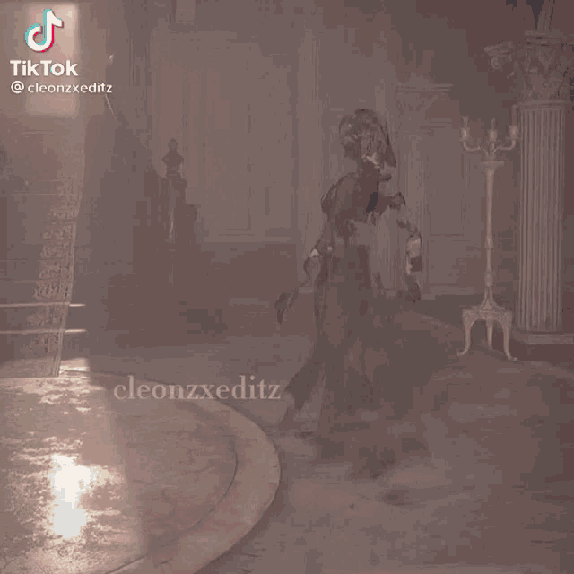a woman in a black dress with a hood and gloves is dancing in a room with a tiktok watermark