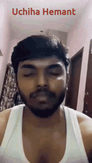 a man with a beard is wearing a white tank top and says uchiha hemant in red