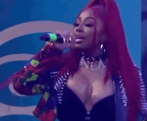 a woman with long red hair is walking on stage