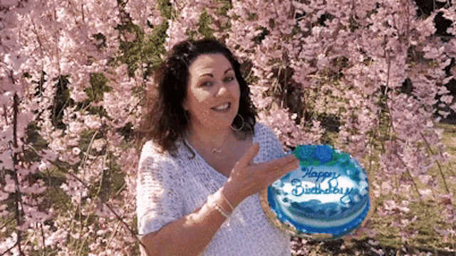 a woman is holding a birthday cake that says happy birthday